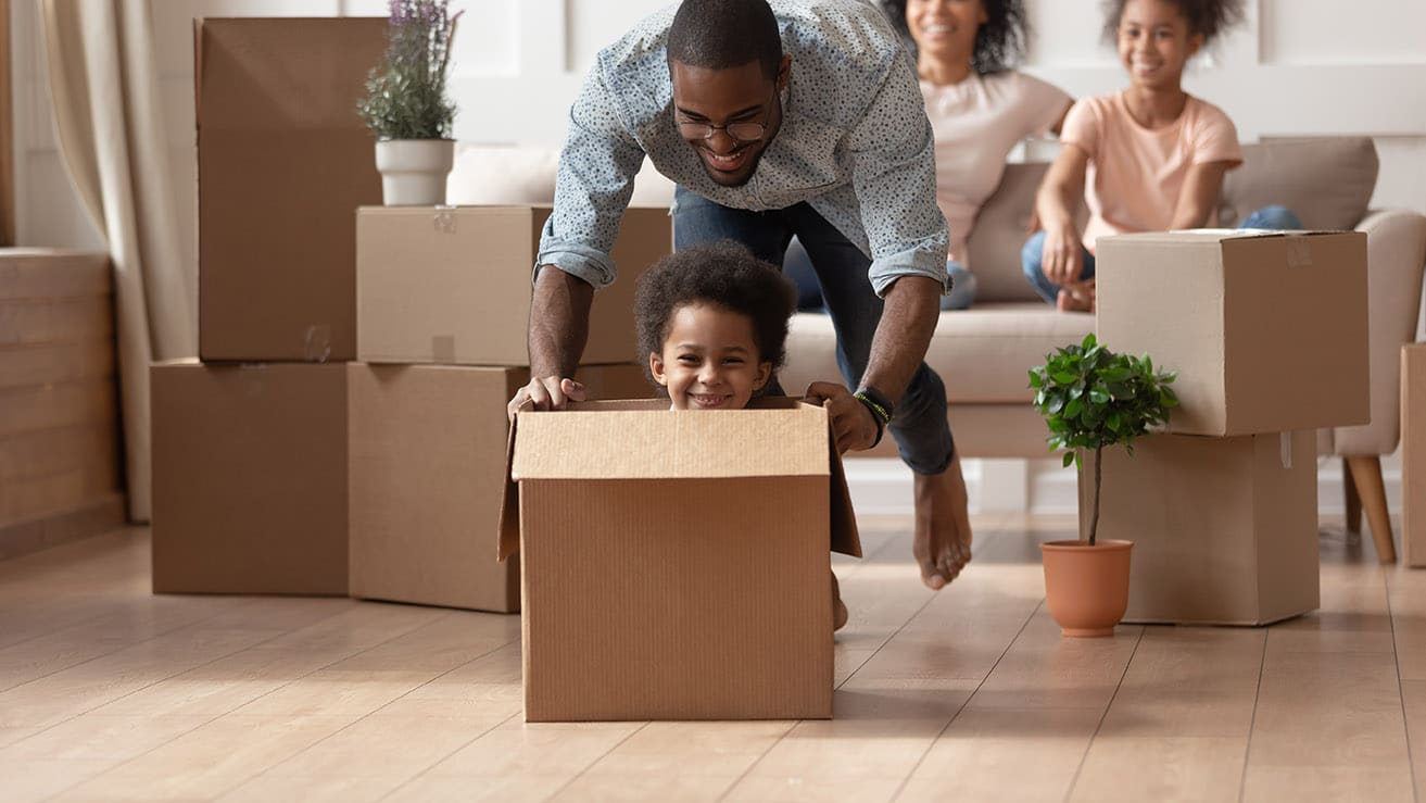 Young dad pushing his son in a box.